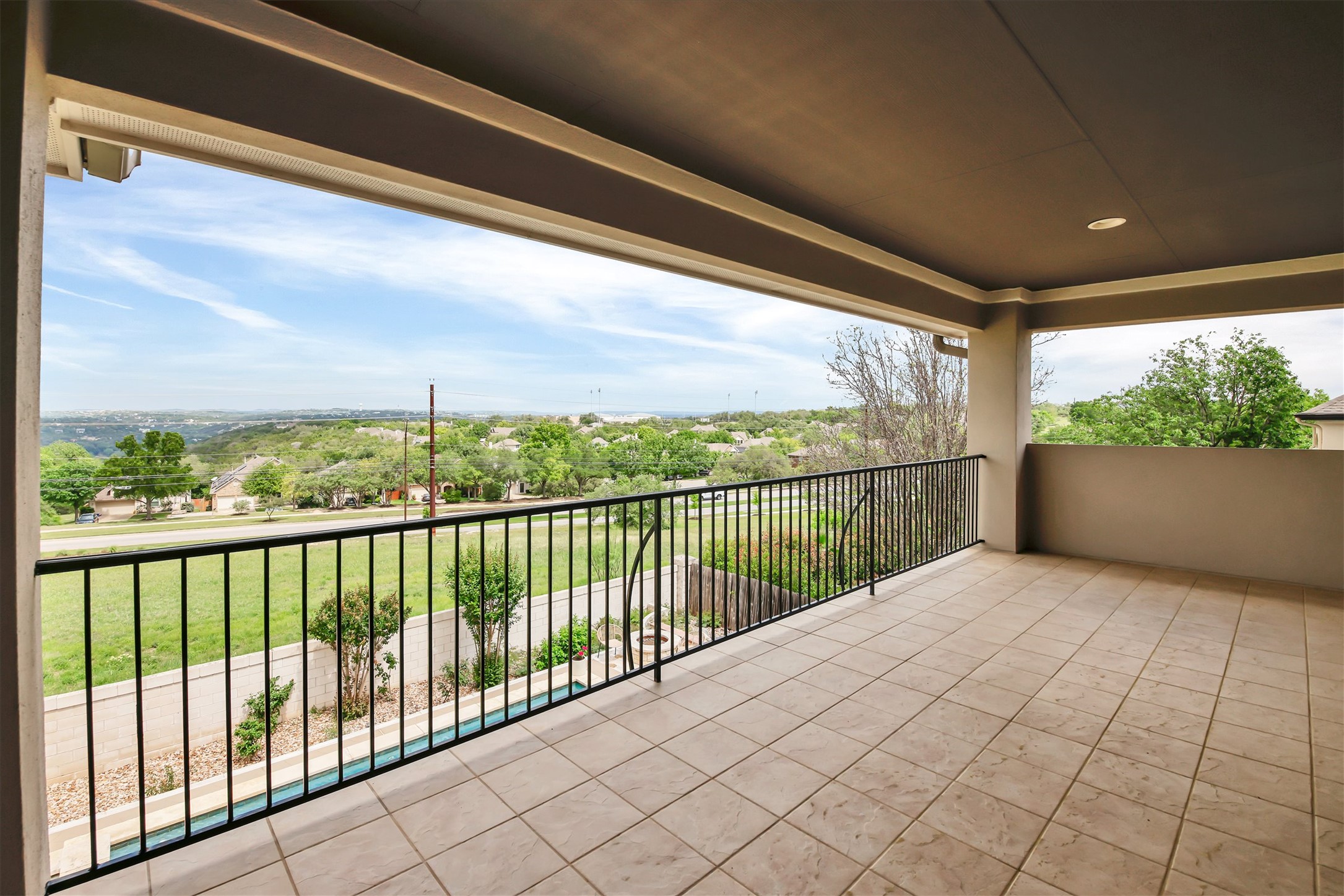 2000 Rio Mesa Drive Austin, TX 78732 - Photo 28 of 39 Spacious covered outdoor living area featuring tiled flooring, a metal railing, and a scenic view of the surrounding landscape