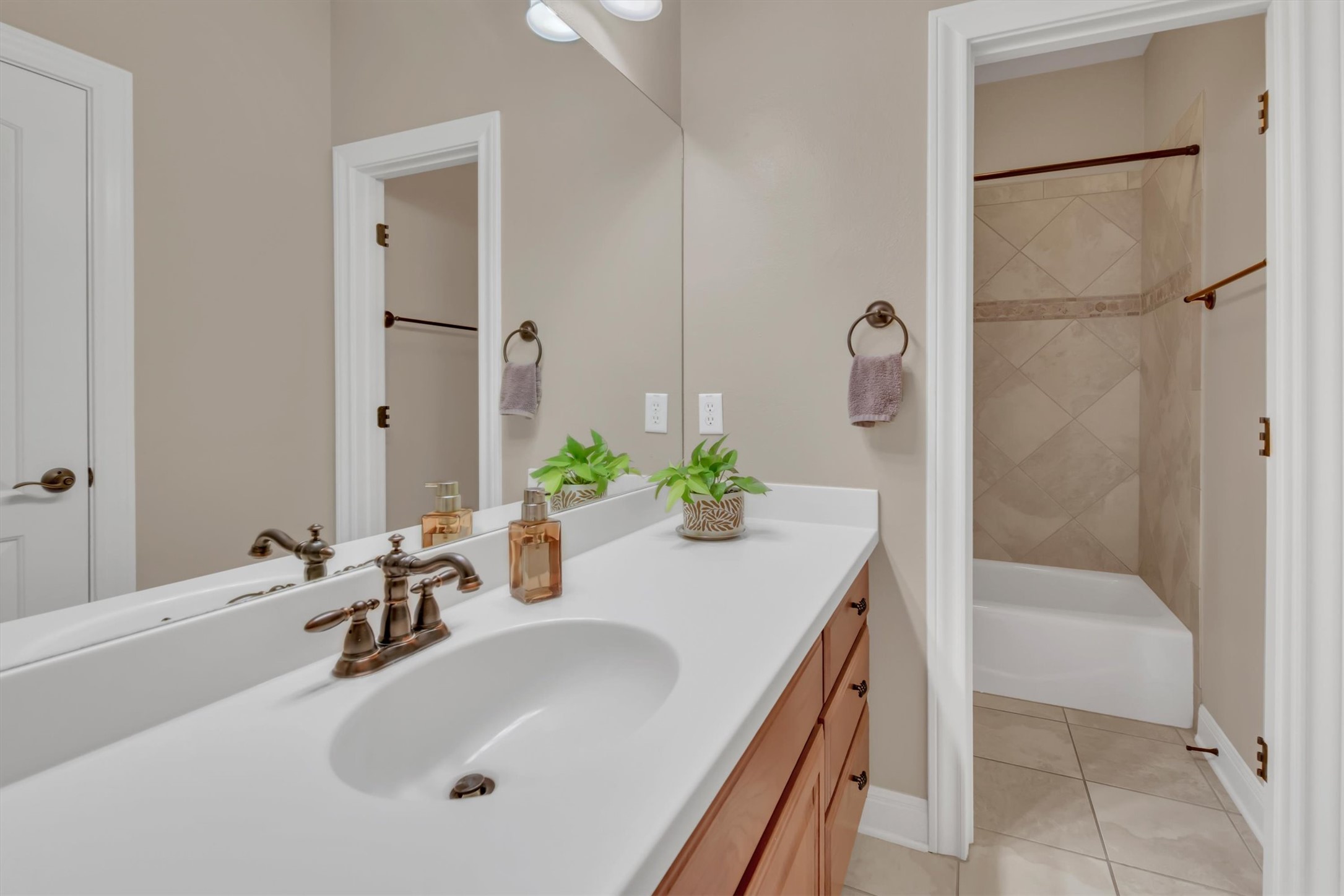 2000 Rio Mesa Drive Austin, TX 78732 - Photo 32 of 39 Bathroom featuring a vanity with a white countertop and an integrated sink, bronze-toned faucet, and cabinetry with bronze-toned pulls