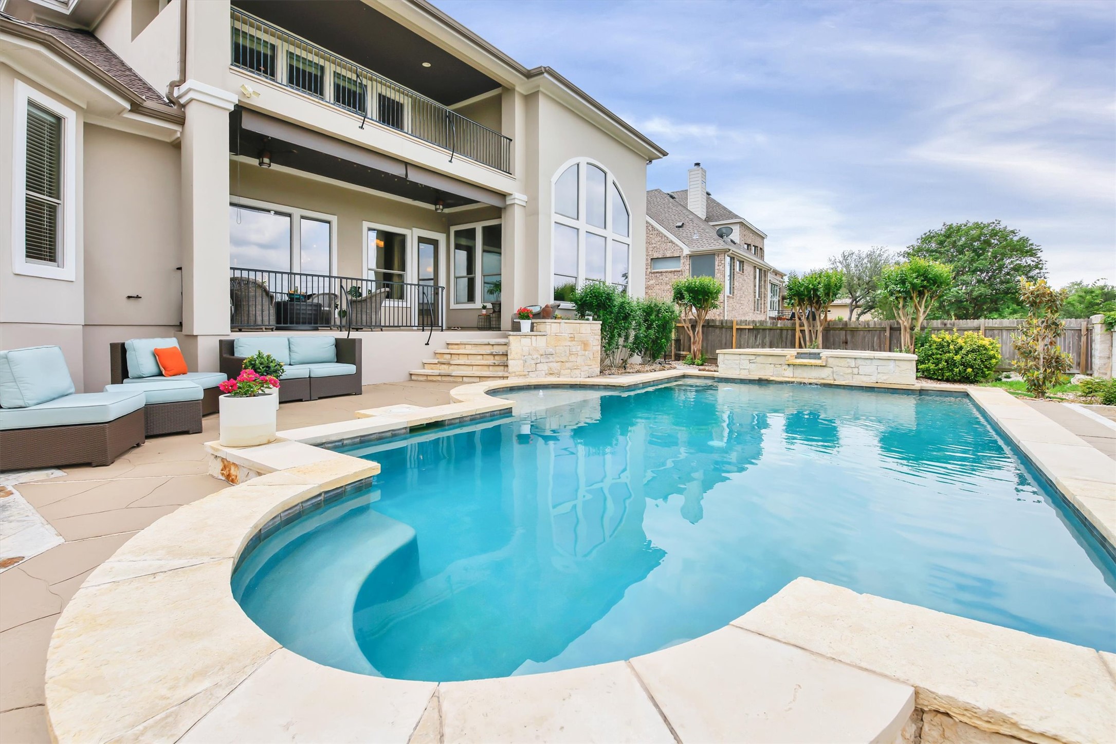 2000 Rio Mesa Drive Austin, TX 78732 - Photo 37 of 39 The property features an outdoor swimming pool with stone coping, a paved patio area, and a stone-clad raised planter with greenery
