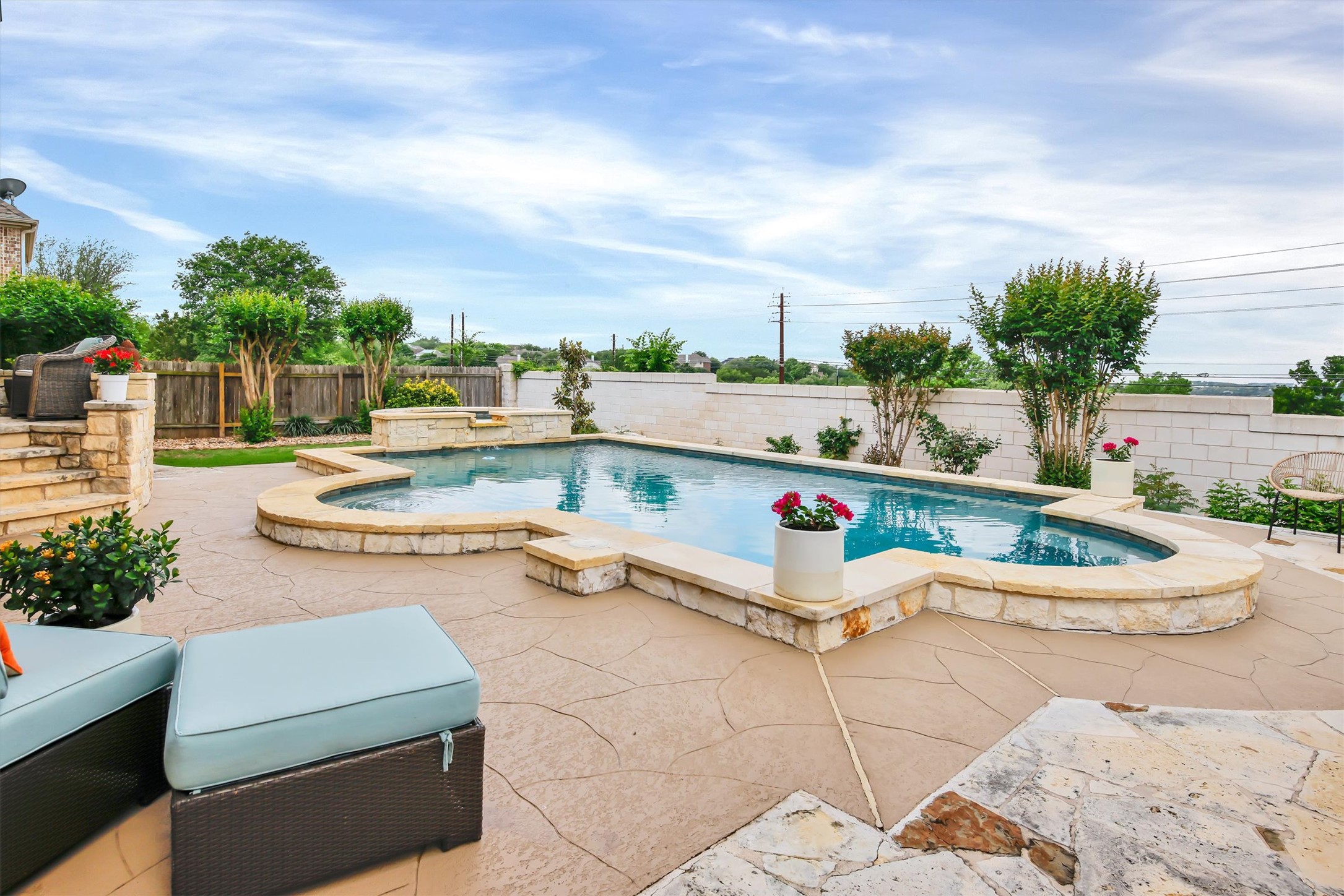 2000 Rio Mesa Drive Austin, TX 78732 - Photo 39 of 39 The property features an outdoor swimming pool with a stone border, surrounded by a stamped concrete patio