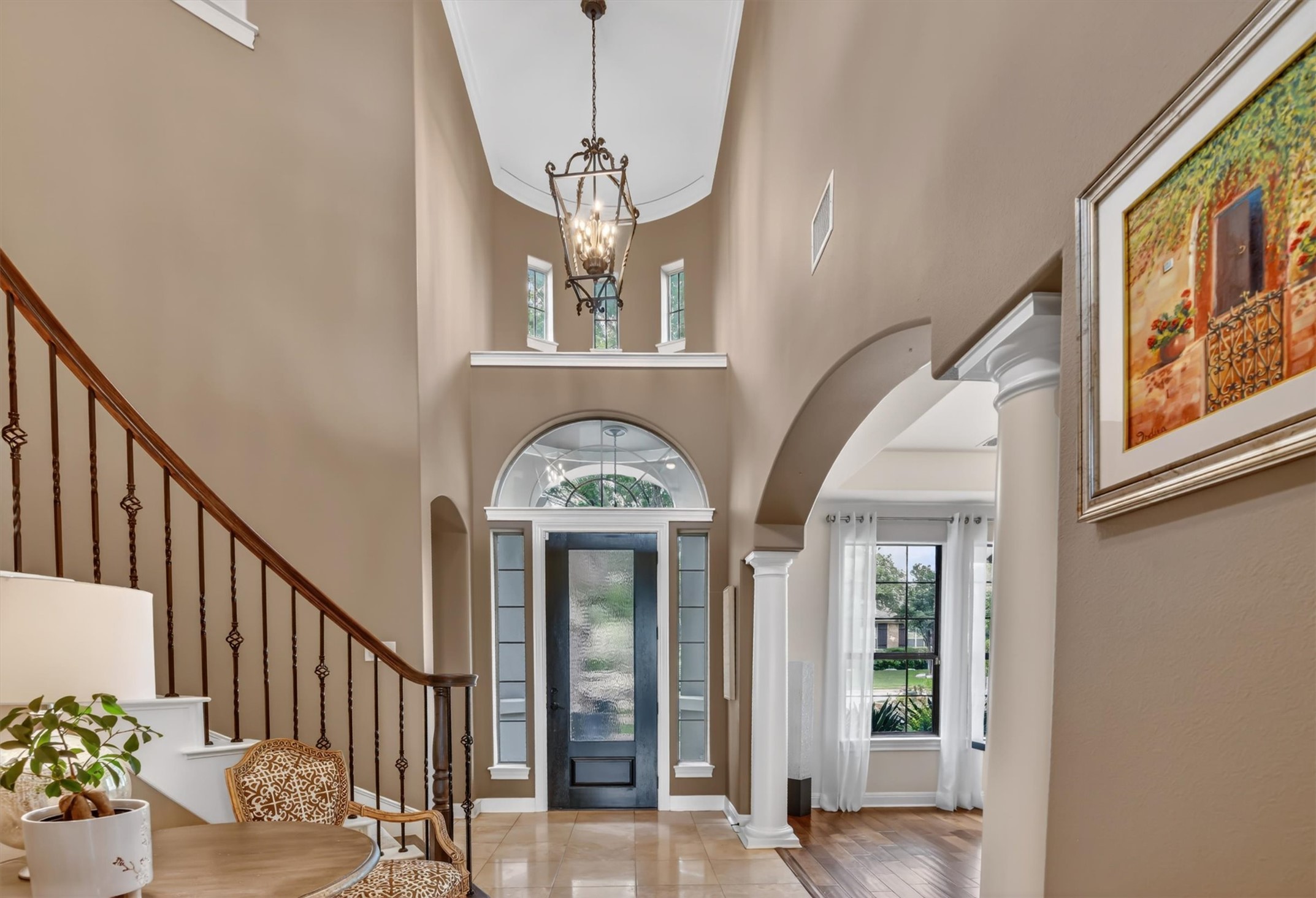 2000 Rio Mesa Drive Austin, TX 78732 - Photo 4 of 39 The property features a grand entryway with a high vaulted ceiling, a decorative chandelier, and a prominent staircase with an ornate railing