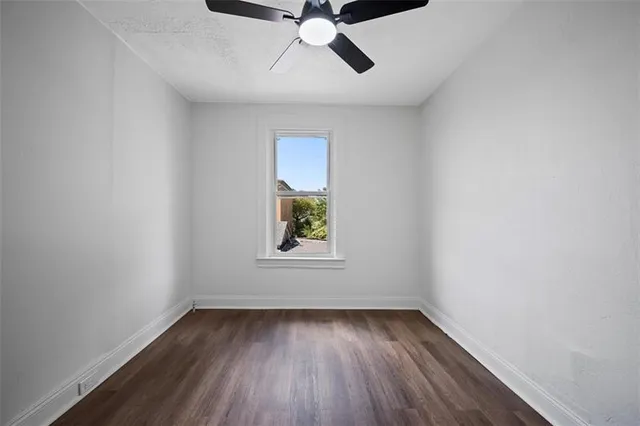 an empty room with a window and a ceiling fan