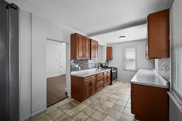 a kitchen with stainless steel appliances granite countertop a sink stove and refrigerator