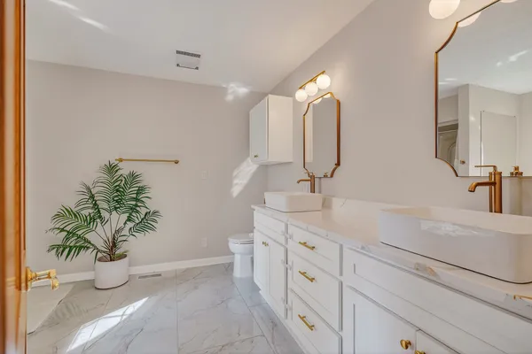 a bathroom with a sink a toilet and a mirror