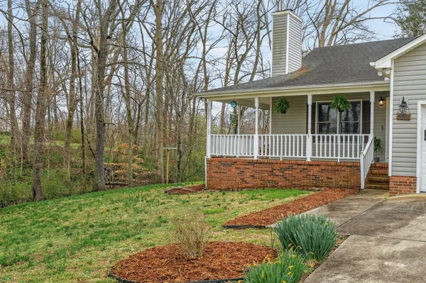 a view of a brick house with a yard and a garden