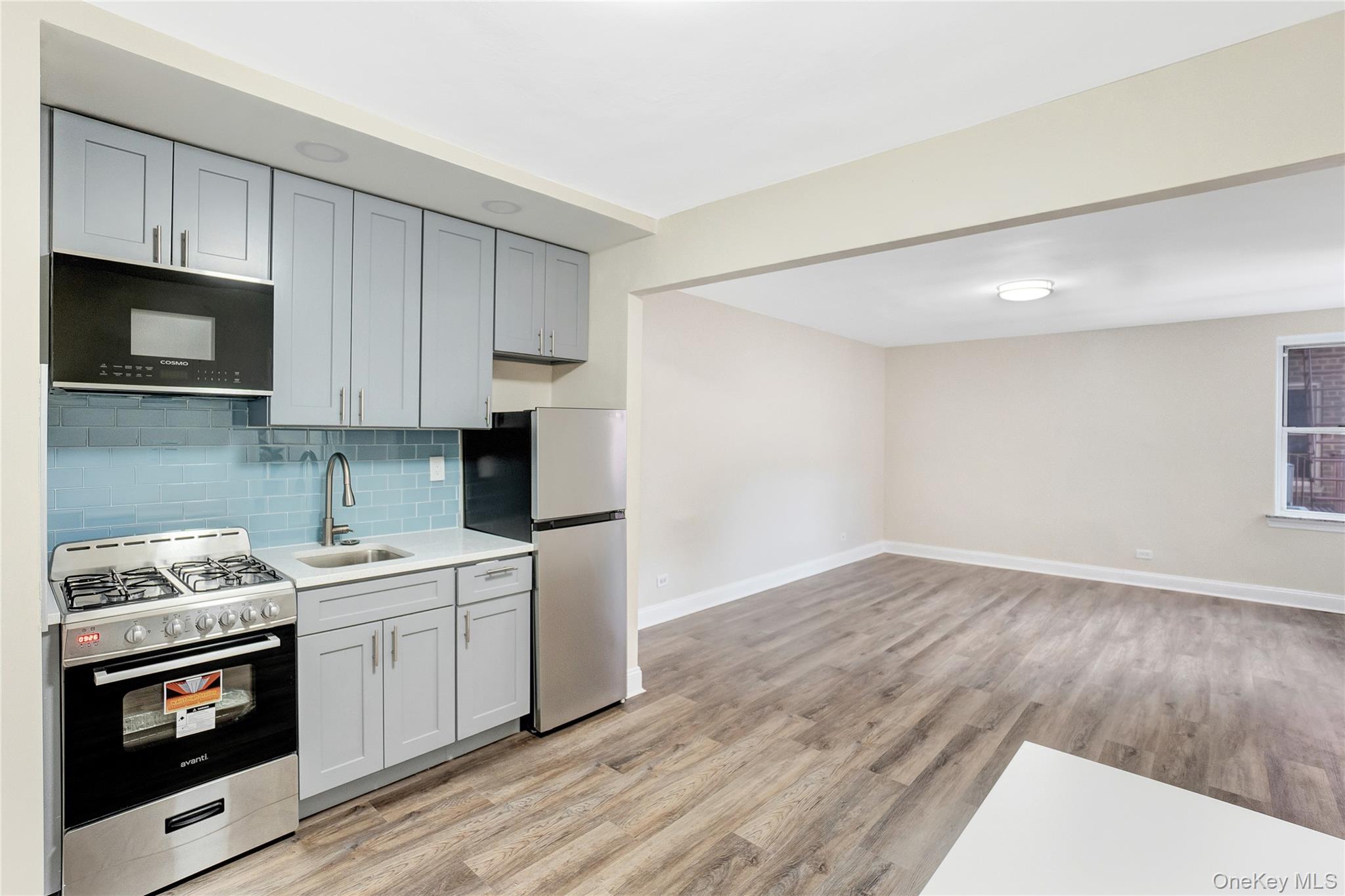 105-24 64th Road, Unit 4L Queens, NY 11375 - Photo 6 of 14 a kitchen with stainless steel appliances a stove a sink and a microwave