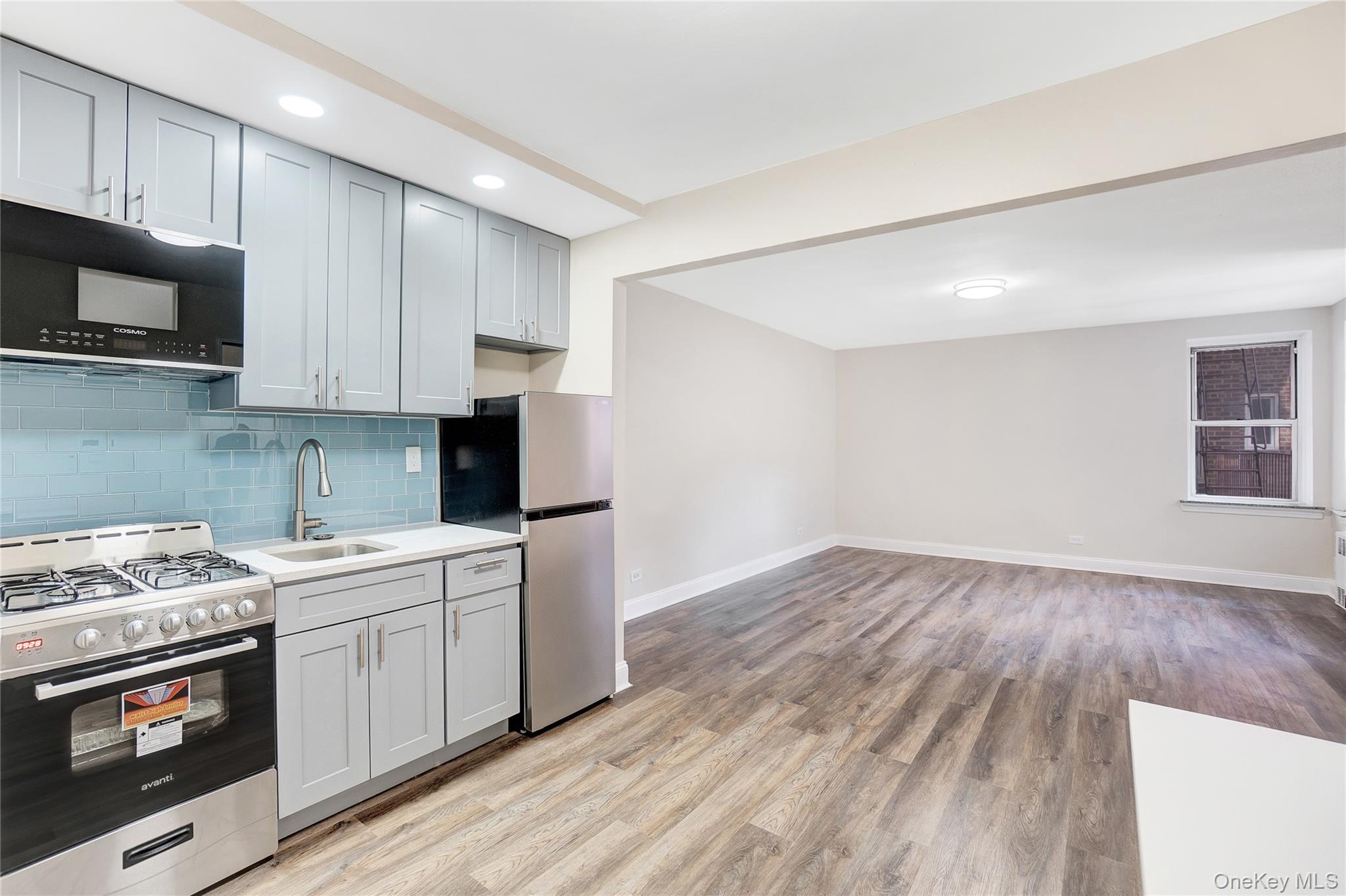105-24 64th Road, Unit 4L Queens, NY 11375 - Photo 14 of 14 a kitchen with a stove a sink and a microwave