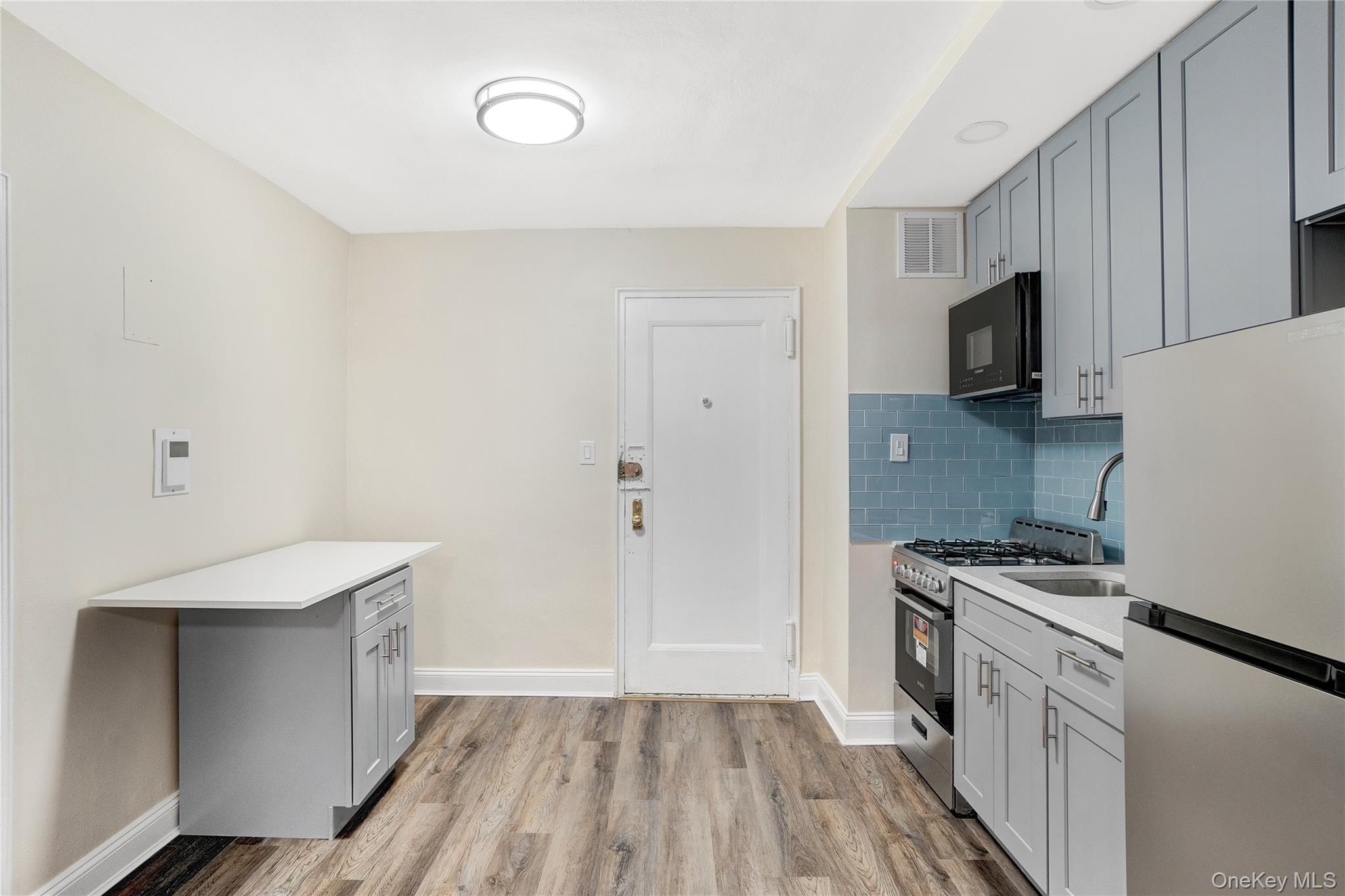 105-24 64th Road, Unit 4L Queens, NY 11375 - Photo 7 of 14 a kitchen with a sink a stove and refrigerator