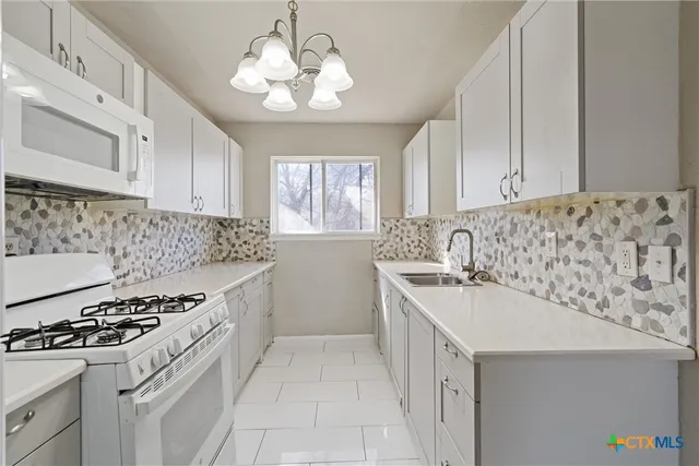a kitchen with a sink stove and cabinets