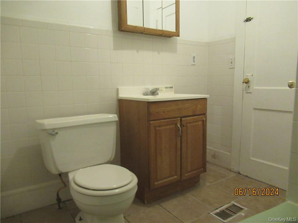 82 North Road Bloomingburg, NY 12721 - Photo 7 of 19 Bathroom with tile floors, vanity, toilet, and tile walls