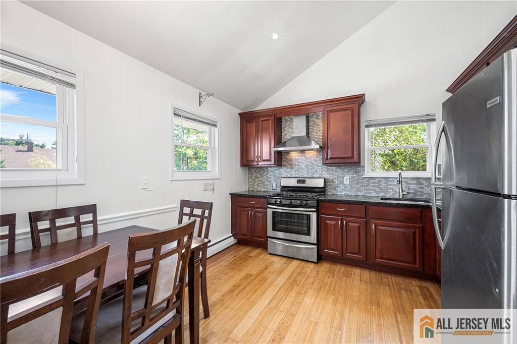 21 Eardley Road Edison, NJ 08817 - Photo 10 of 40 a kitchen with stainless steel appliances granite countertop a stove a refrigerator a sink a dining table and chairs with wooden floor