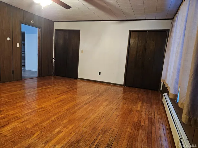an empty room with wooden floor and closet