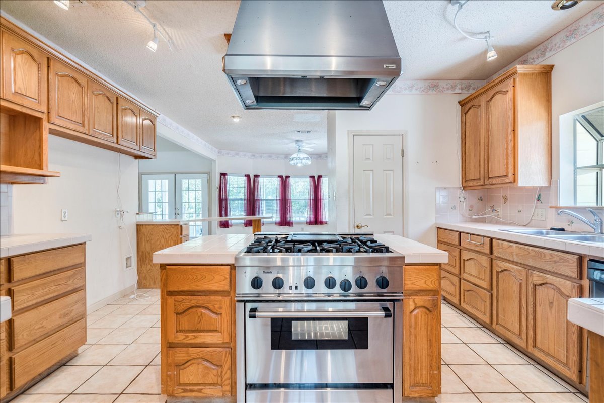19106 Eyerley Road Manor, TX 78653 - Photo 10 of 40 A well-equipped culinary space boasts a large range and tile flooring, ready for your next meal.