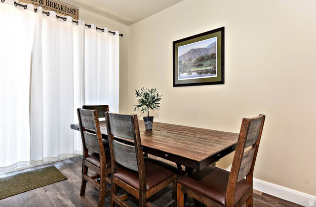 1622 Canyon Tree Drive St. George, UT 84770 - Photo 25 of 34 Dining space featuring wood-finish flooring, light-toned walls, and a large window with white curtains