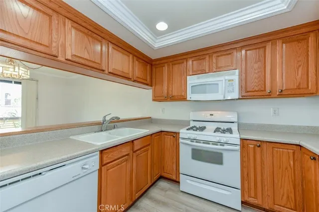 a kitchen with stainless steel appliances granite countertop a sink dishwasher stove and cabinets with wooden floor