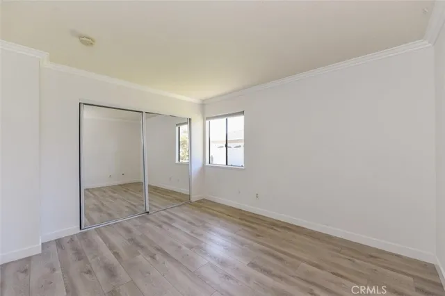 an empty room with wooden floor and window