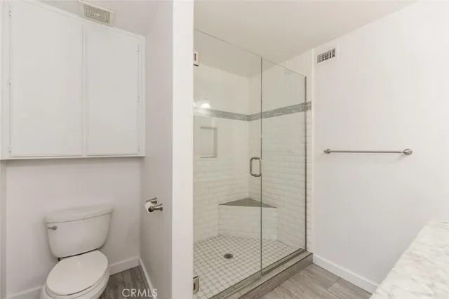 a bathroom with a toilet and a shower