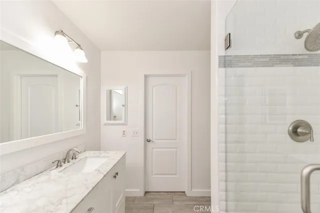 a bathroom with a double vanity sink a mirror and a shower