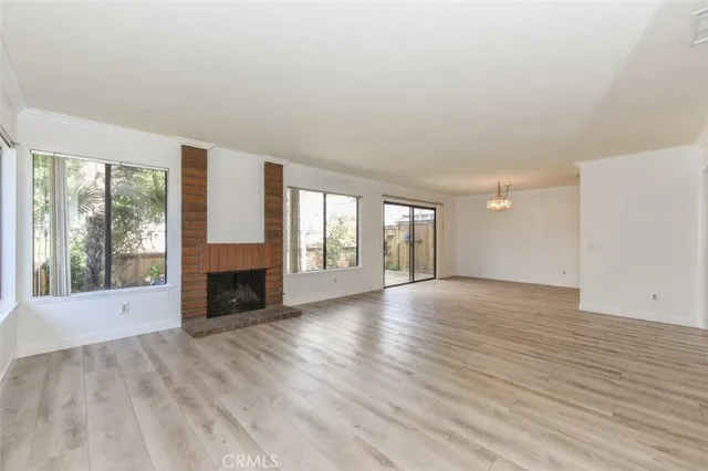 wooden floor fireplace and windows in an empty room