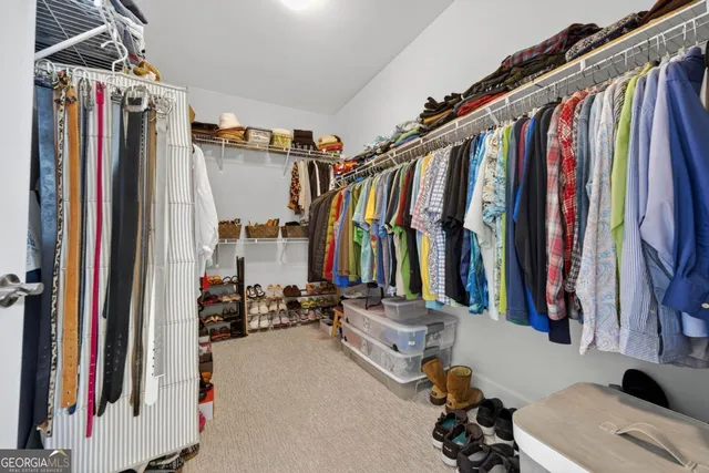 a view of walk in closet with clothes and shoes