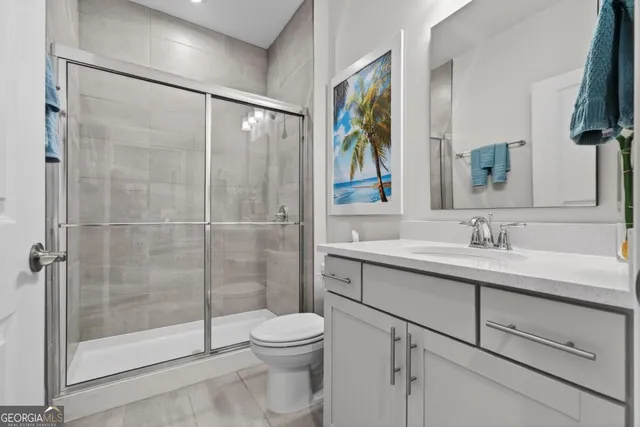 a bathroom with a shower sink vanity mirror and toilet