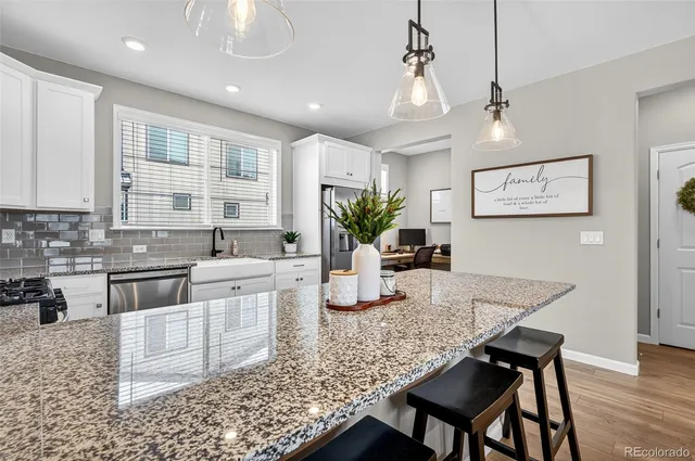 a kitchen with stainless steel appliances granite countertop a kitchen island a stove a cabinets a sink and a counter space