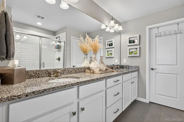 a bathroom with a granite countertop sink a large mirror and a shower