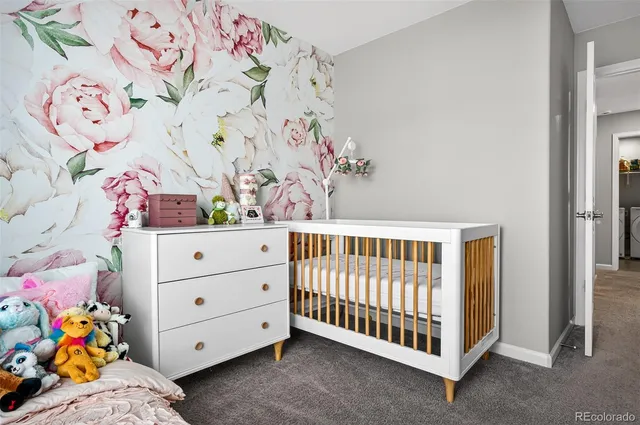 a bedroom with baby bed and window