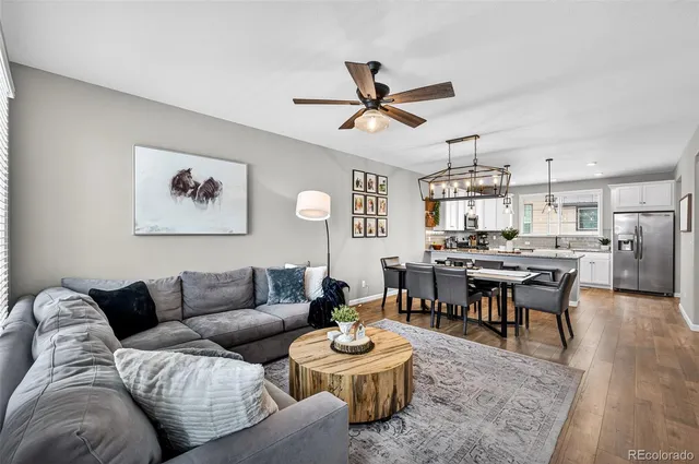 a living room with furniture kitchen view and a chandelier