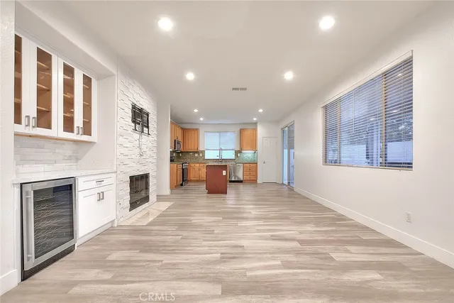 a kitchen with stainless steel appliances granite countertop a stove a sink and a refrigerator with wooden floors