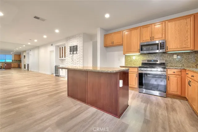 a kitchen with stainless steel appliances granite countertop a sink and a refrigerator
