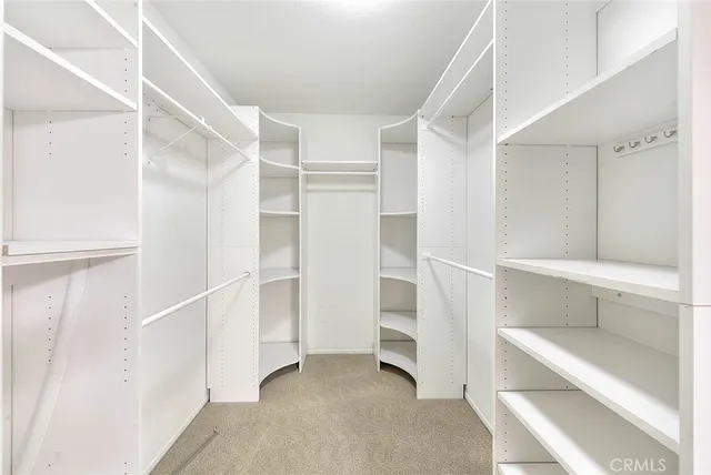 an empty room with windows and chandelier fan