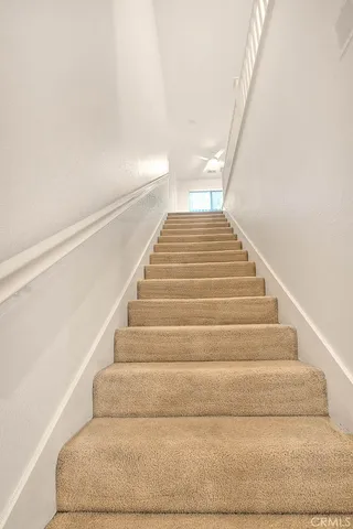 a view of a hallway to rooms and stairs