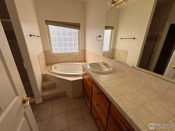 a bathroom with a granite countertop sink a toilet a mirror and bathtub
