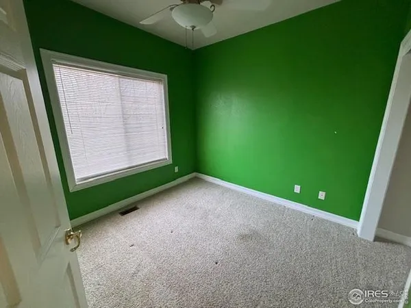 a view of an empty room with a window and a fireplace