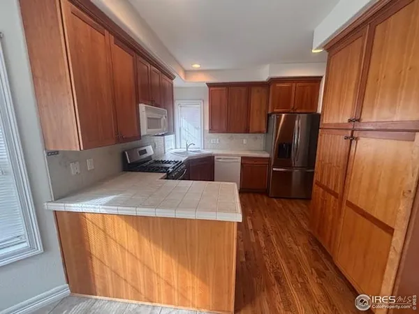 a kitchen with wooden cabinets a refrigerator and a stove