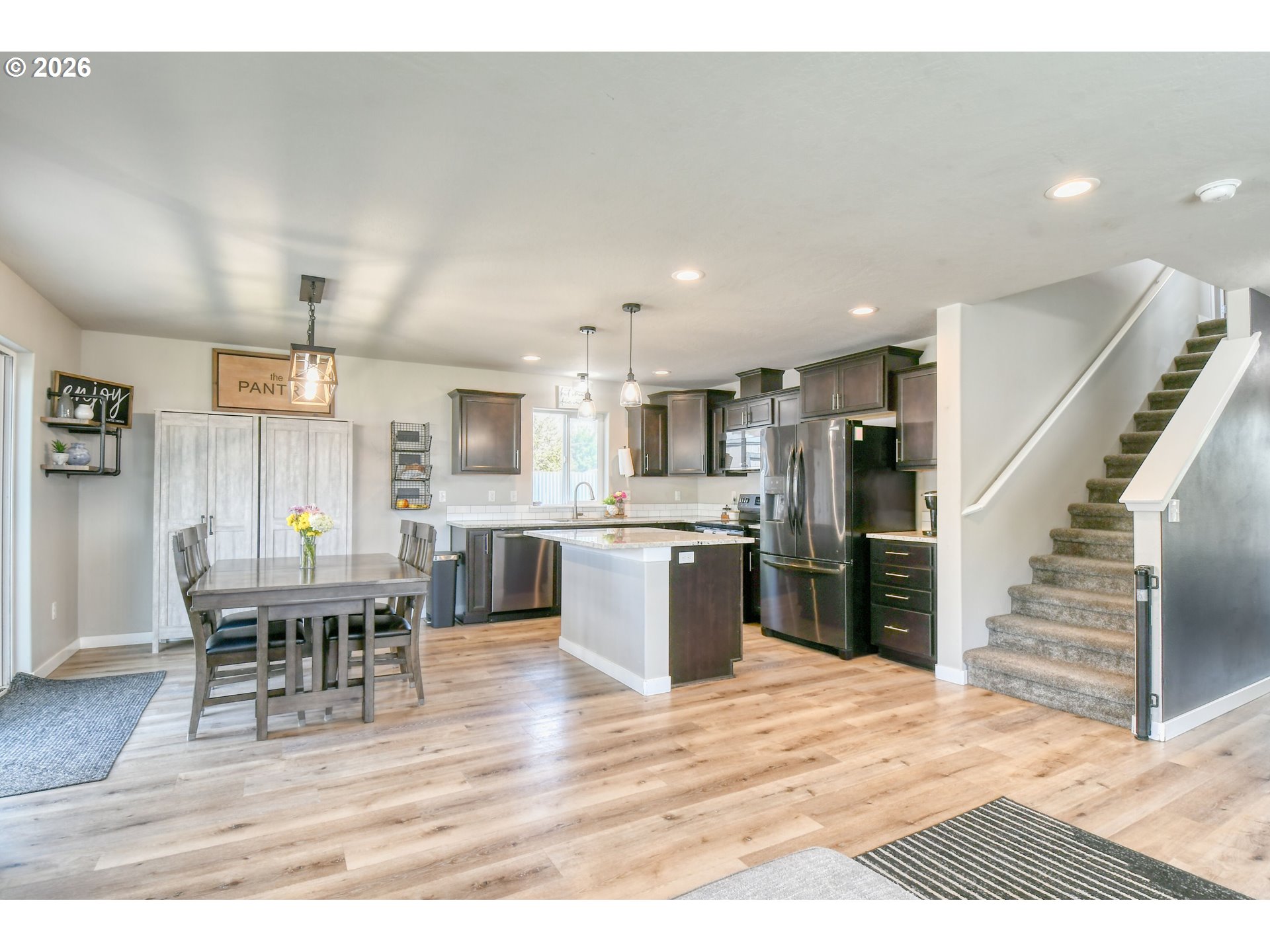233 East Jefferson Street Athena, OR 97813 - Photo 7 of 36 a kitchen with stainless steel appliances kitchen island granite countertop a table chairs and a refrigerator