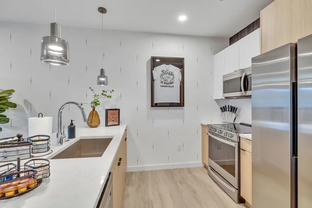 a kitchen with stainless steel appliances granite countertop a sink stove and refrigerator