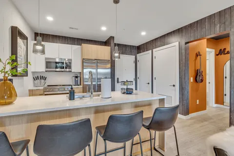 a large kitchen with kitchen island a large counter top space a sink stainless steel appliances and cabinets