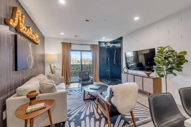a living room with furniture a flat screen tv and a large window