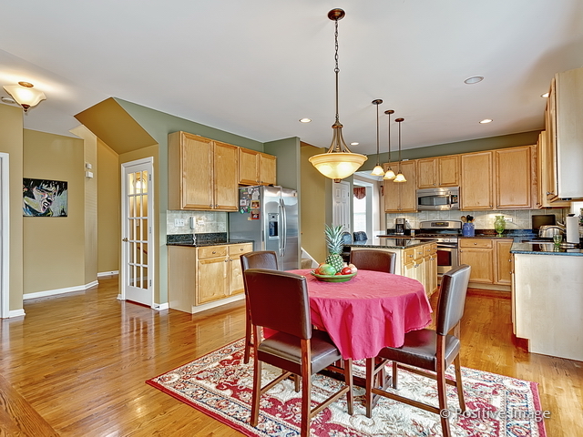 1463 Saddleridge Place Bartlett, IL 60103 - Photo 12 of 27 a dining area with stainless steel appliances kitchen island granite countertop a dining table chairs and a refrigerator