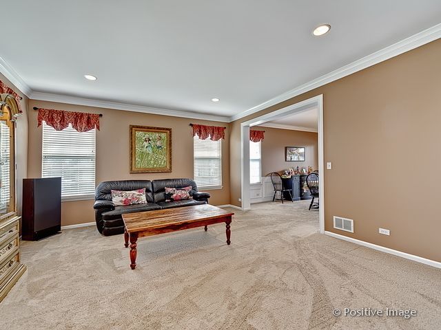 1463 Saddleridge Place Bartlett, IL 60103 - Photo 5 of 27 a living room with furniture gym equipment and a flat screen tv