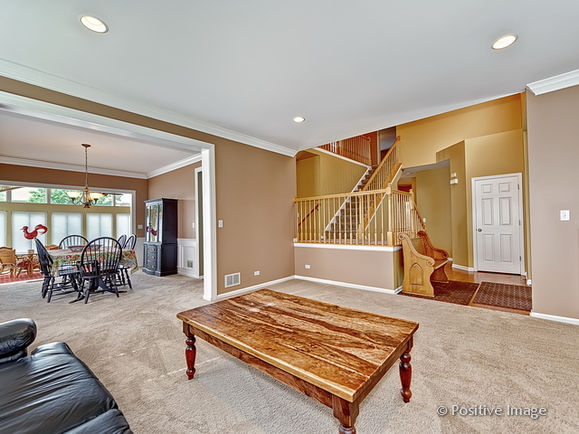 1463 Saddleridge Place Bartlett, IL 60103 - Photo 6 of 27 a living room with a rug and a table