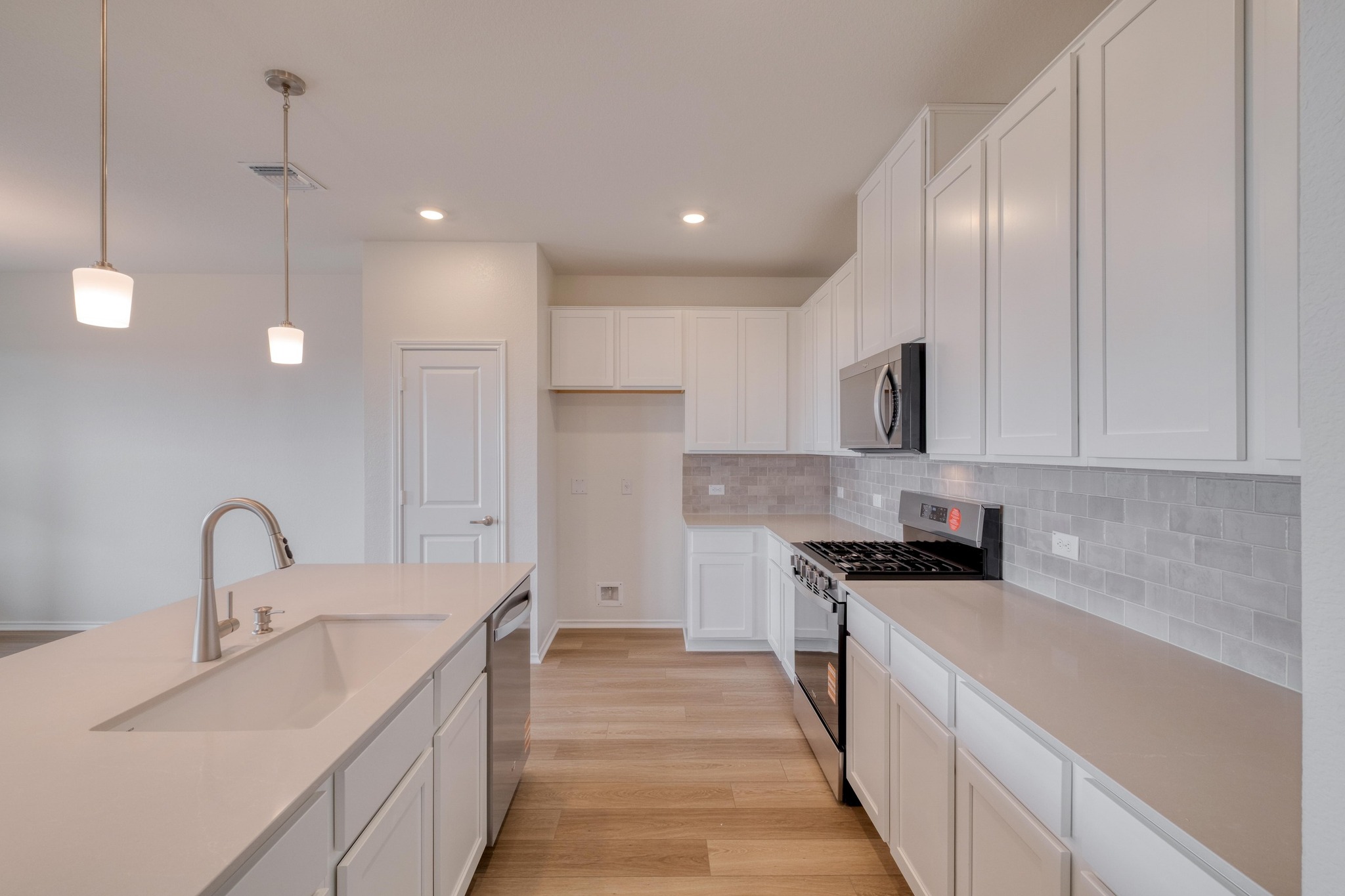 4608 Centola Loop Round Rock, TX 78665 - Photo 5 of 33 a kitchen with counter top space a sink stainless steel appliances and cabinets