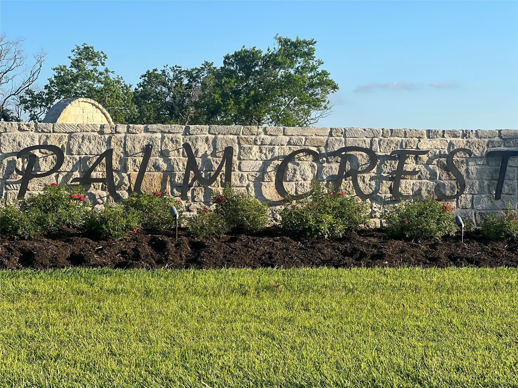 3711 Palm Crest Drive Rosharon, TX 77583 - Photo 9 of 9 This photo showcases a welcoming stone entrance sign for "Palm Crest," surrounded by well-maintained landscaping and greenery, indicating a desirable residential community.
