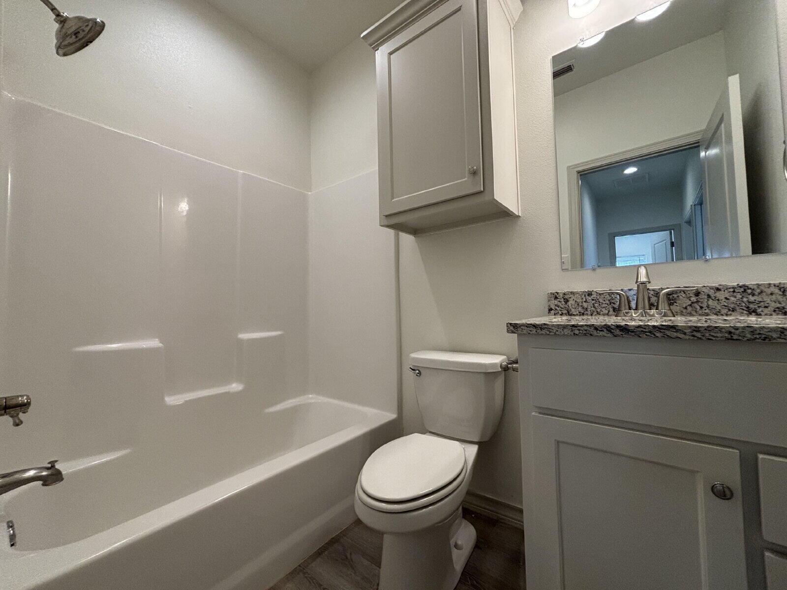 2407 Quitman Avenue, Unit B Lubbock, TX 79407 - Photo 11 of 13 a bathroom with a granite countertop toilet a sink and bathtub