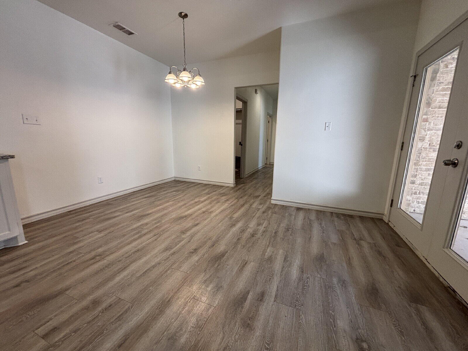 2407 Quitman Avenue, Unit B Lubbock, TX 79407 - Photo 6 of 13 a view of an empty room with wooden floor and a window