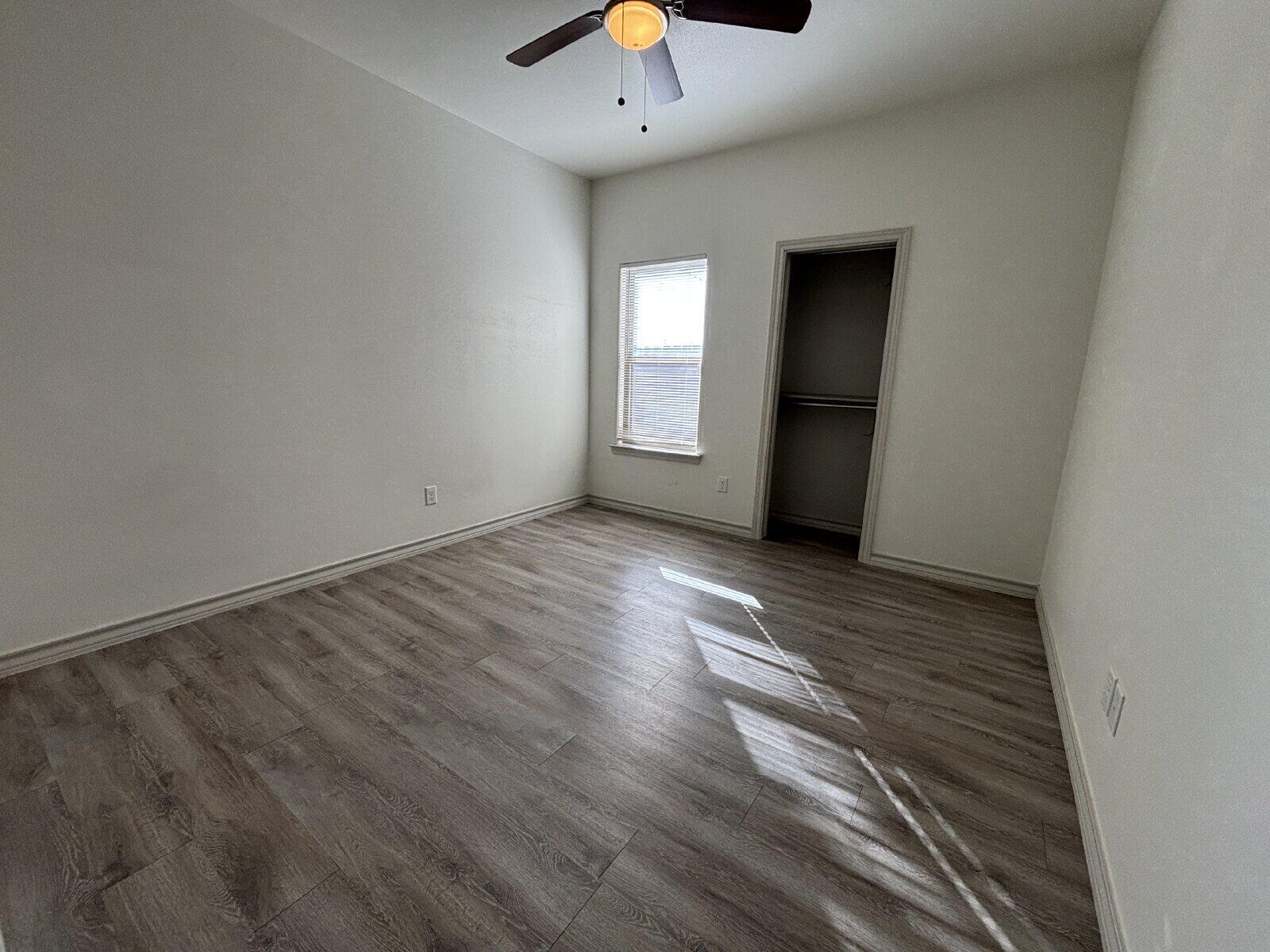 2407 Quitman Avenue, Unit B Lubbock, TX 79407 - Photo 9 of 13 a view of an empty room with window and wooden floor