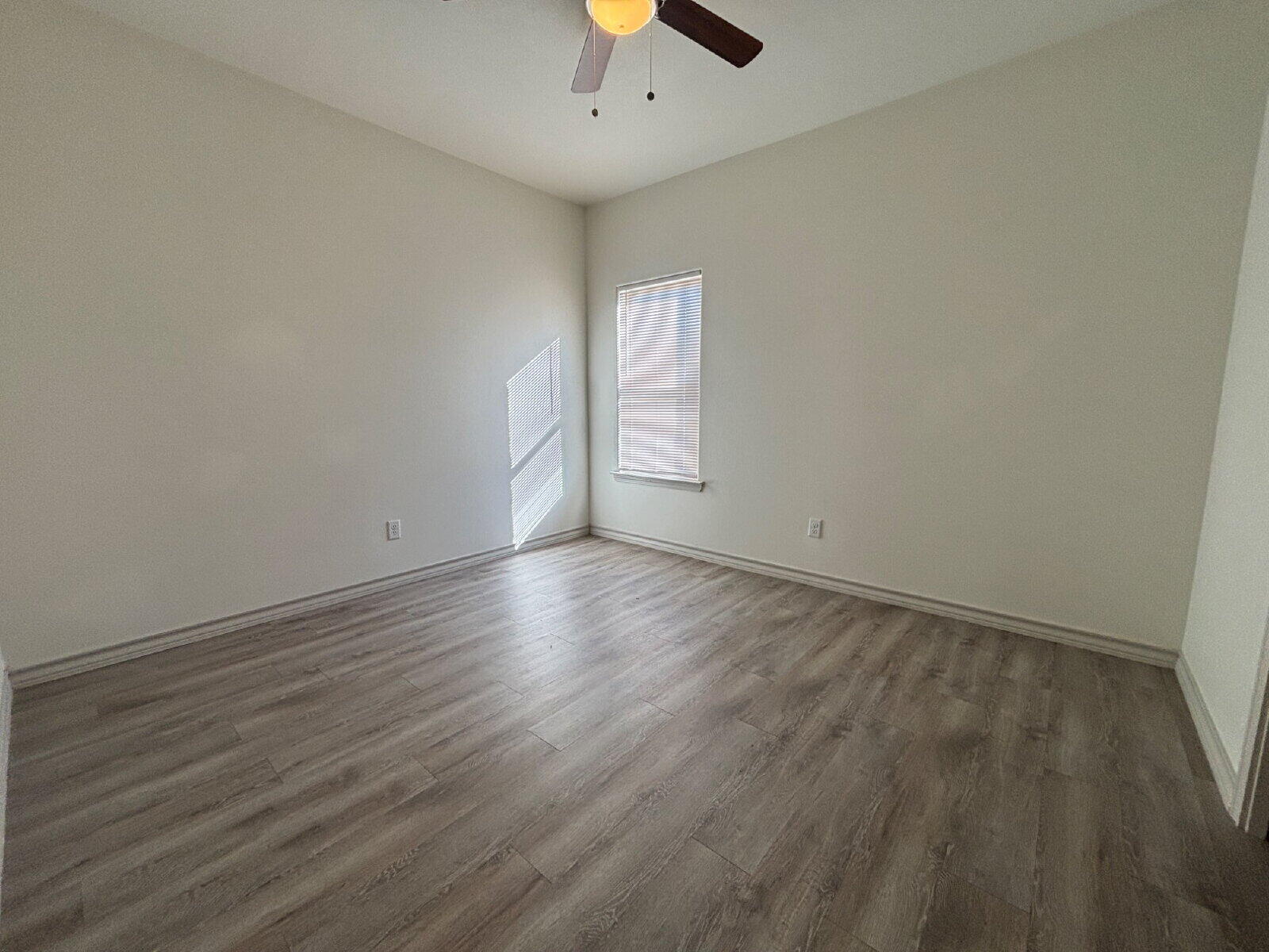 2407 Quitman Avenue, Unit B Lubbock, TX 79407 - Photo 10 of 13 an empty room with wooden floor and chandelier fan