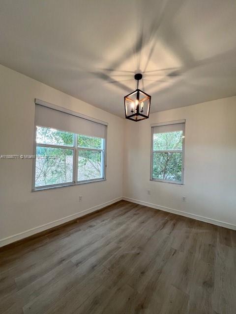 1000 Southwest 12th Court, Unit 4 Miami, FL 33135 - Photo 15 of 21 an empty room with wooden floor chandelier and windows